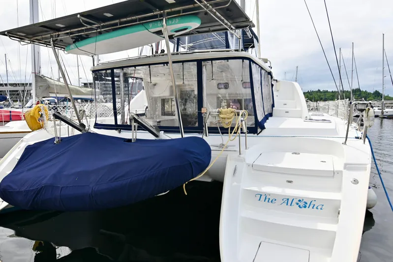  Yacht Photos Pics 2009 Lagoon 440 catamaran docked at marina, featuring covered seating and equipment.