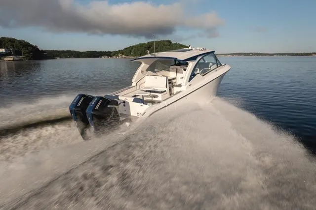  Yacht Photos Pics 2026 Fountain 39 DX boat cruising on a calm lake under a clear sky.