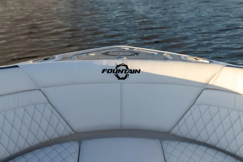  Yacht Photos Pics 2026 Fountain 39 DX boat interior with logo, featuring white quilted seating by the water.