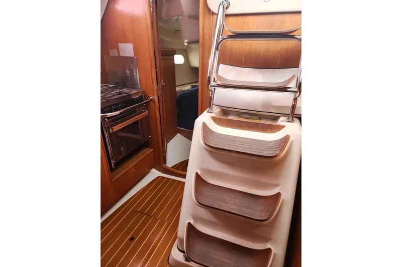 Seaquel Yacht Photos Pics Interior of 2003 Hunter 386 sailboat with wooden steps and compact kitchen area.