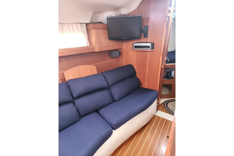 Seaquel Yacht Photos Pics Interior of 2003 Hunter 386 yacht with blue sofa and mounted TV.