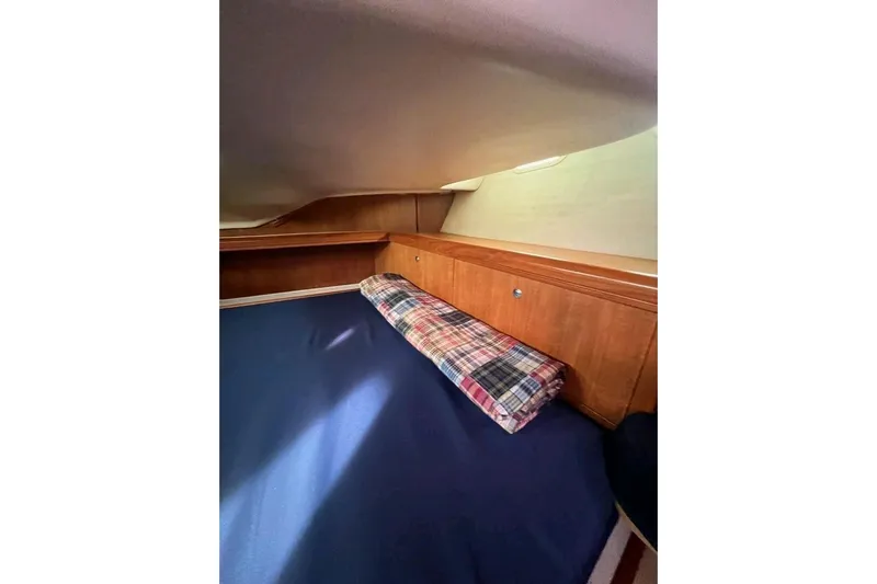 Seaquel Yacht Photos Pics Interior cabin of 2003 Hunter 386 sailboat with wooden storage and plaid cushion.