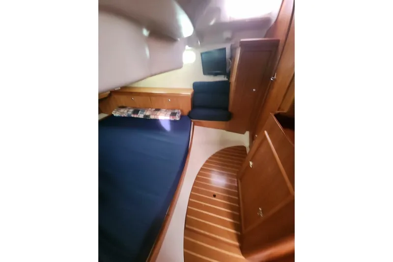 Seaquel Yacht Photos Pics Interior of 2003 Hunter 386 sailboat cabin with bed, wooden cabinets, and seating area.