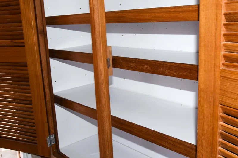 Sangaris Yacht Photos Pics Wooden cabinet shelves inside a 2005 Manta 42 MkII boat.