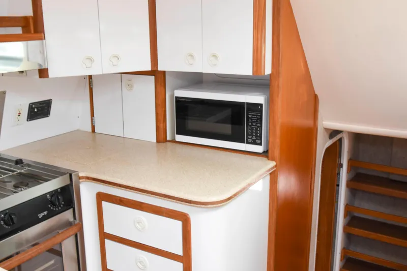 Sangaris Yacht Photos Pics Compact kitchen area in a 2005 Manta 42 MkII yacht with microwave and stove.