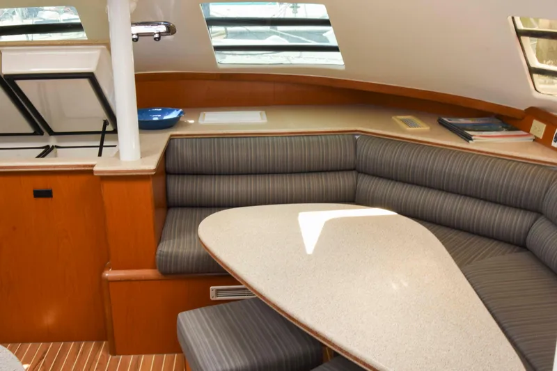 Sangaris Yacht Photos Pics Interior of 2005 Manta 42 MkII yacht with striped seating and triangular table.