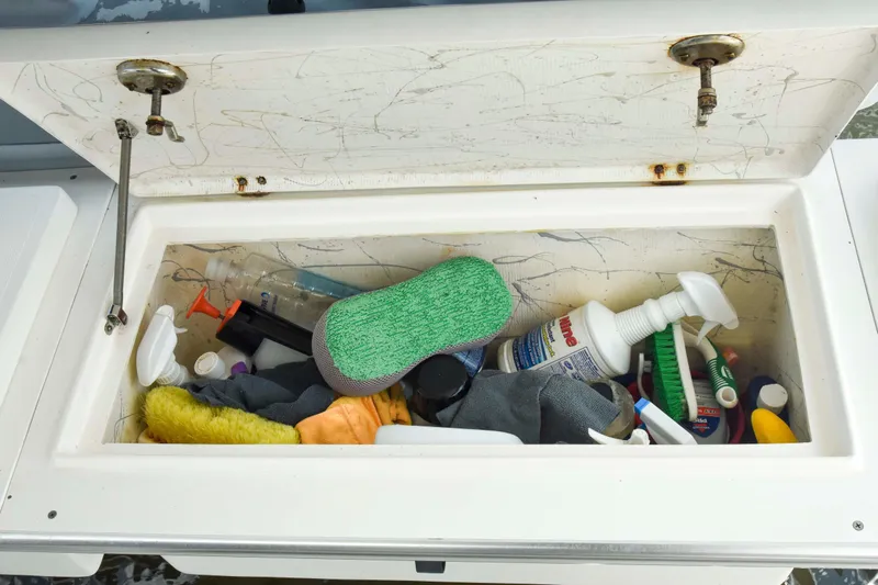 Sangaris Yacht Photos Pics Open storage compartment on 2005 Manta 42 MkII, filled with cleaning supplies and tools.