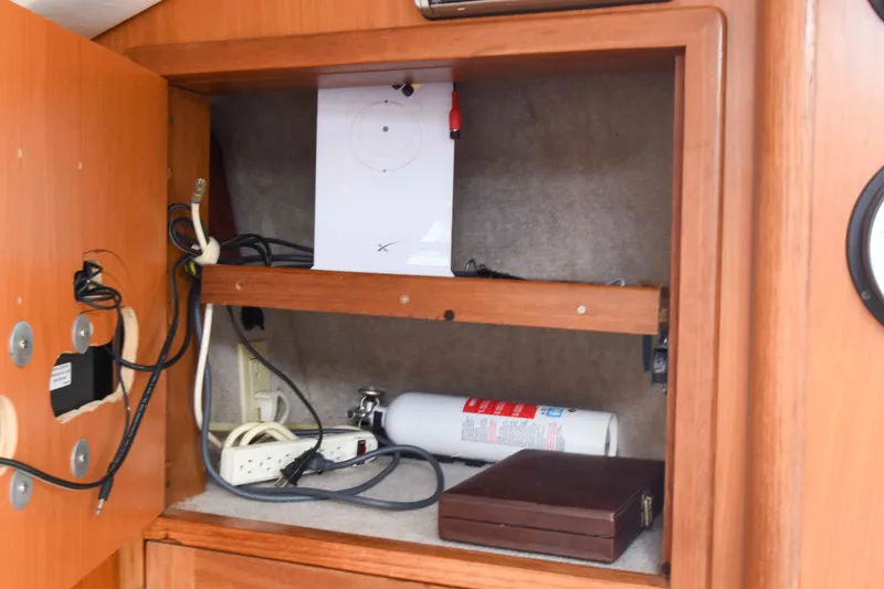 Sangaris Yacht Photos Pics Cabinet interior of 2005 Manta 42 MkII with fire extinguisher and cables.