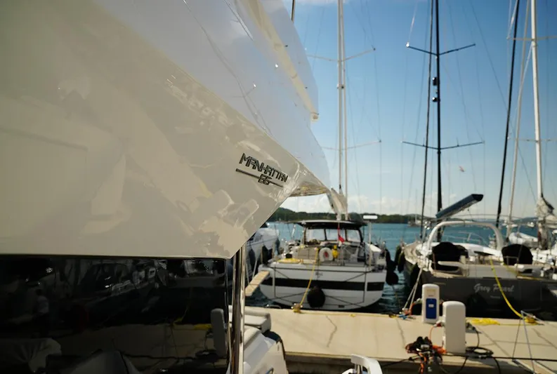  Yacht Photos Pics 2017 Sunseeker Manhattan 66 yacht docked at marina with sailboats in background.