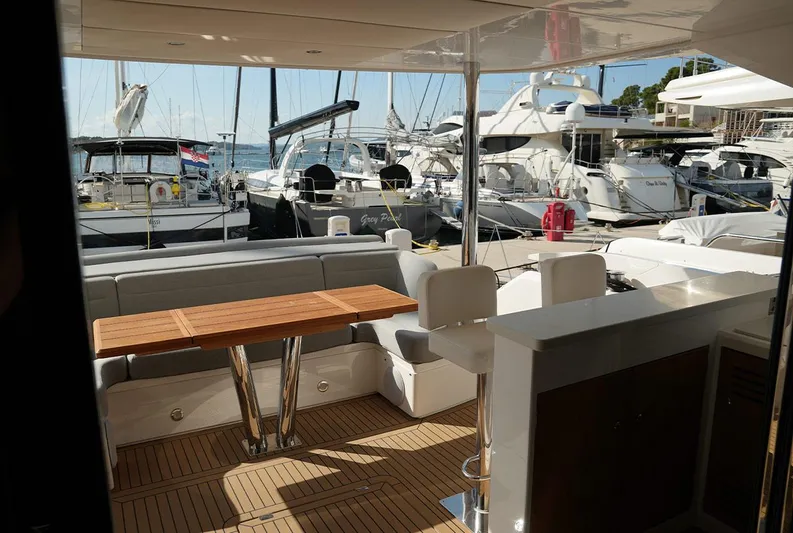  Yacht Photos Pics Luxurious Sunseeker Manhattan 66 yacht interior with elegant seating and wooden table, docked at marina.