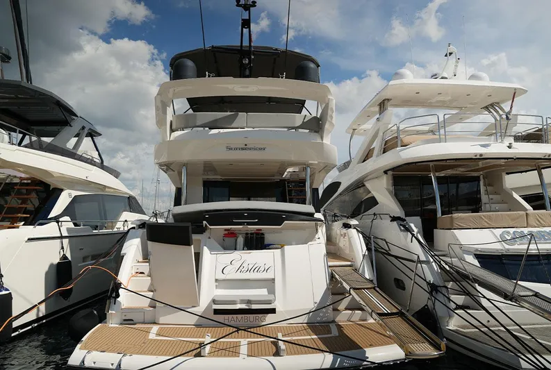 Yacht Photos Pics 2017 Sunseeker Manhattan 66 yacht docked, rear view, with neighboring boats under a cloudy sky.