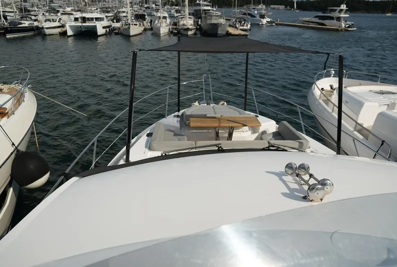  Yacht Photos Pics Sunseeker Manhattan 66 yacht, 2017 model, docked in a marina with other boats.