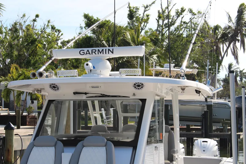  Yacht Photos Pics 2024 Everglades 395 Center Console boat with Garmin equipment, docked near palm trees.
