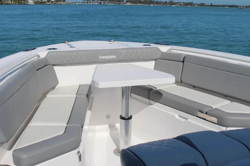  Yacht Photos Pics 2024 Everglades 395 Center Console boat with spacious seating and table on calm water.