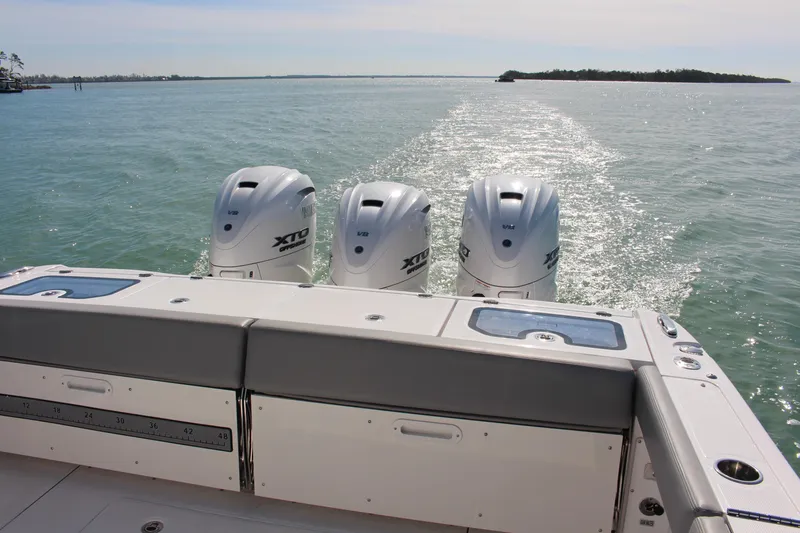  Yacht Photos Pics 2024 Everglades 395 Center Console boat with triple outboard engines on open water.