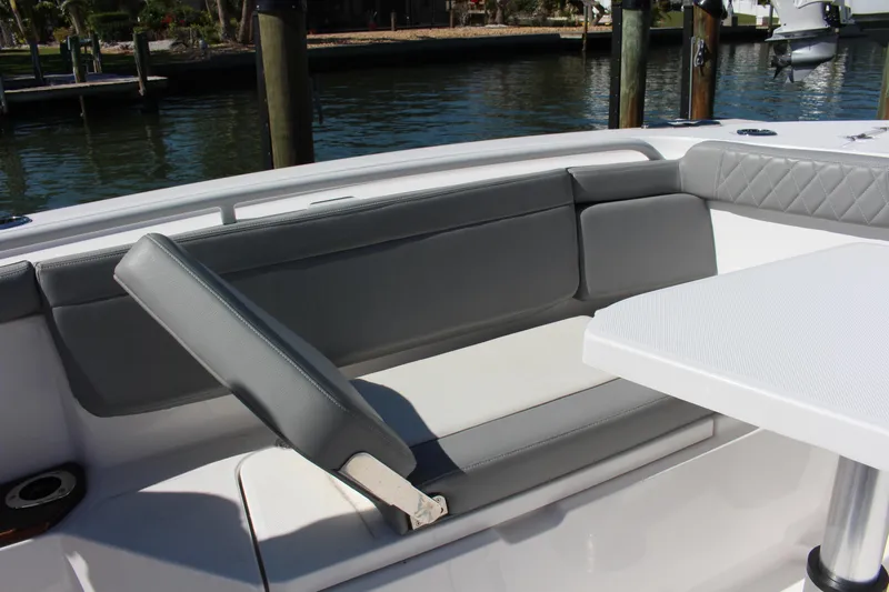  Yacht Photos Pics 2024 Everglades 395 Center Console boat seating area with gray cushions and table.