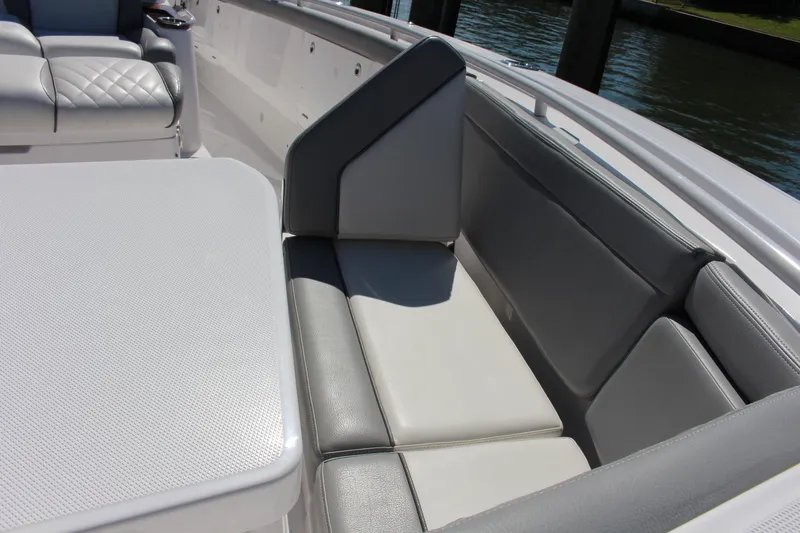  Yacht Photos Pics 2024 Everglades 395 Center Console boat interior with cushioned seating and table.