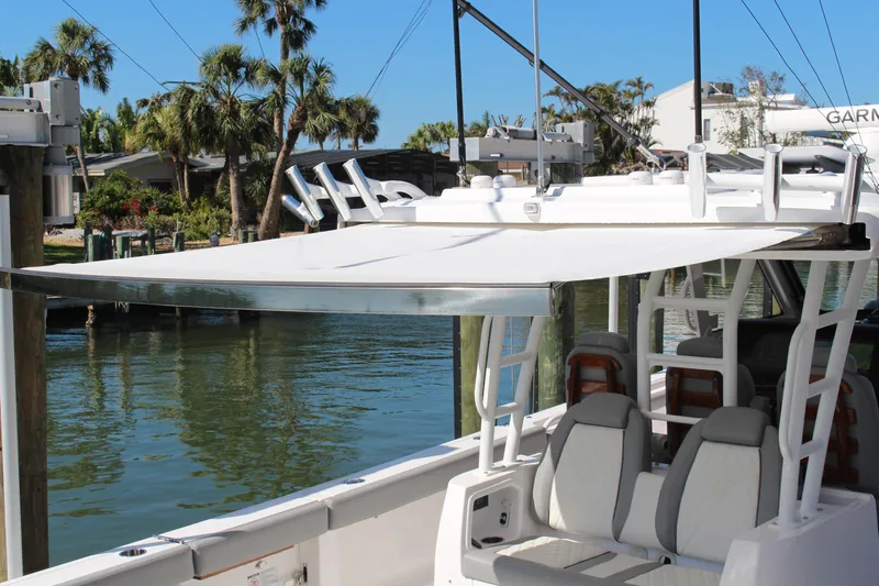  Yacht Photos Pics 2024 Everglades 395 Center Console boat with sunshade, docked near palm trees.