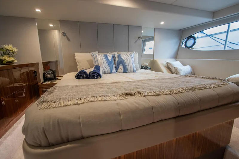  Yacht Photos Pics Luxurious bedroom interior of 2024 Riviera 4600 SY yacht with elegant bedding and decor.