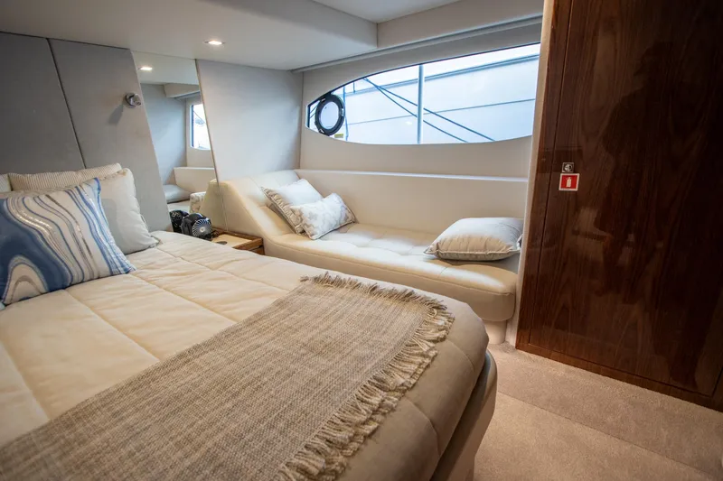  Yacht Photos Pics Luxurious interior of 2024 Riviera 4600 SY yacht with cozy bed and seating area.