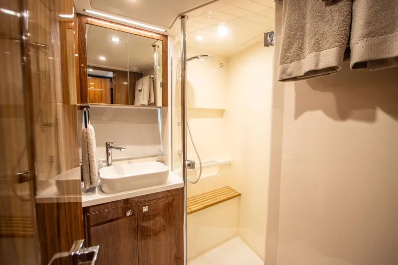  Yacht Photos Pics Luxurious bathroom in 2024 Riviera 4600 SY yacht with modern fixtures and wooden accents.