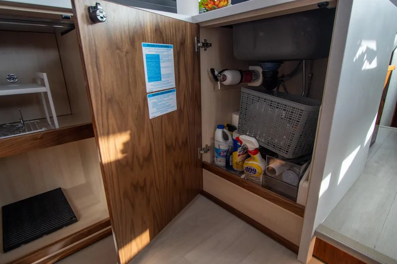  Yacht Photos Pics Open cabinet in 2024 Riviera 4600 SY yacht, storing cleaning supplies and equipment.