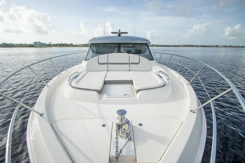  Yacht Photos Pics 2024 Riviera 4600 SY luxury yacht on calm water, showcasing sleek design and spacious deck.