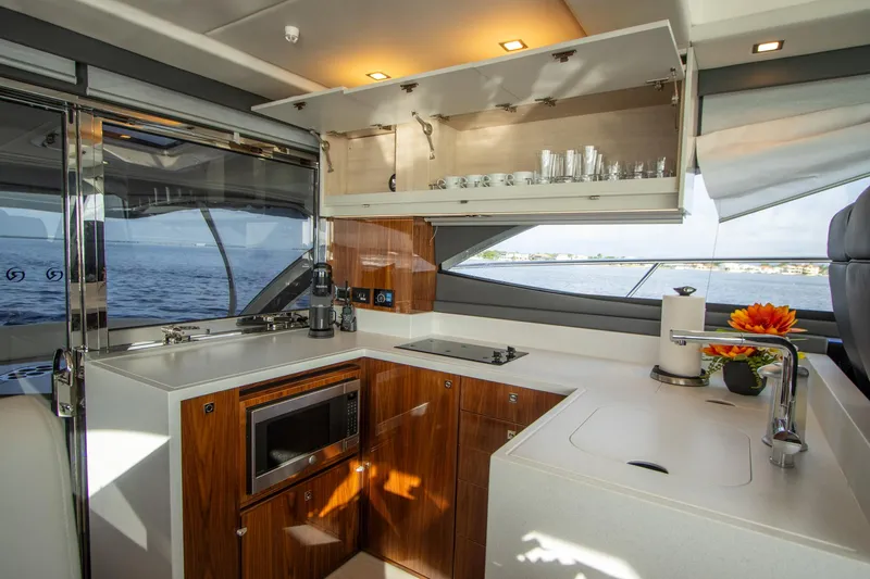  Yacht Photos Pics Luxurious 2024 Riviera 4600 SY yacht kitchen with modern amenities and ocean view.