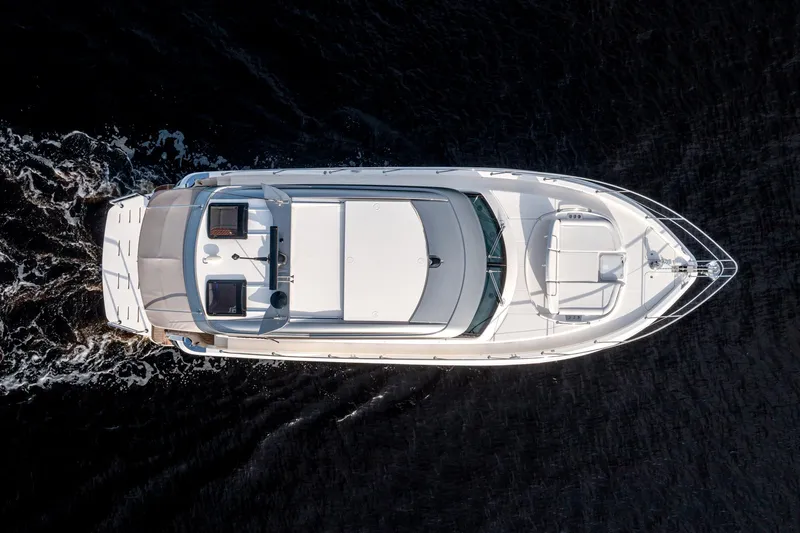  Yacht Photos Pics Aerial view of 2024 Riviera 4600 SY luxury yacht cruising on dark water.