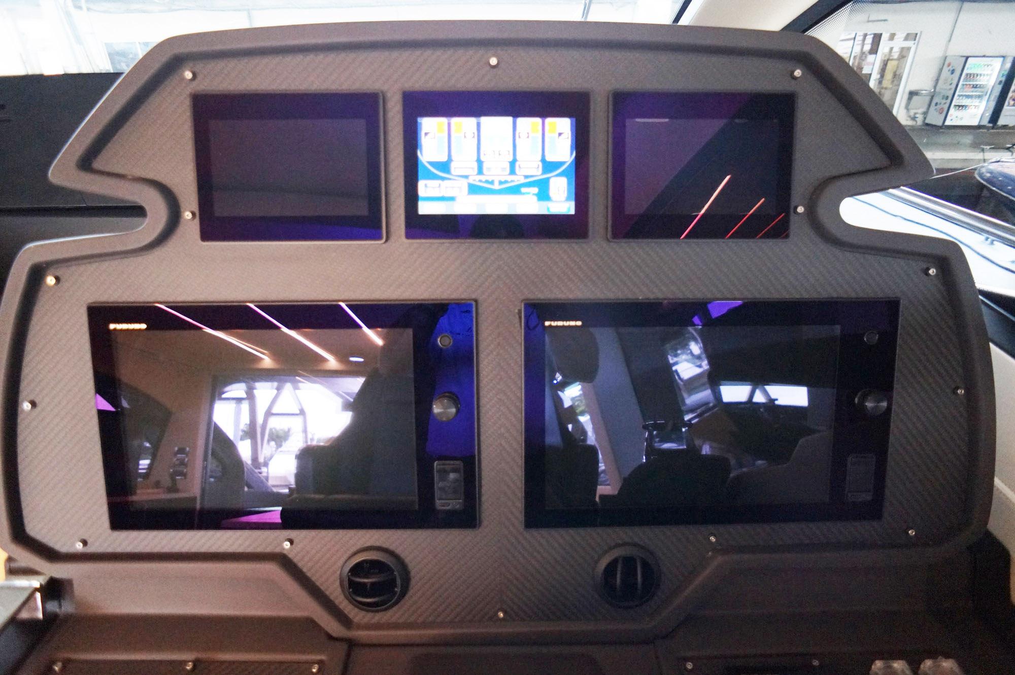 Control panel of a 2016 Pershing 70 yacht with multiple screens and modern design.