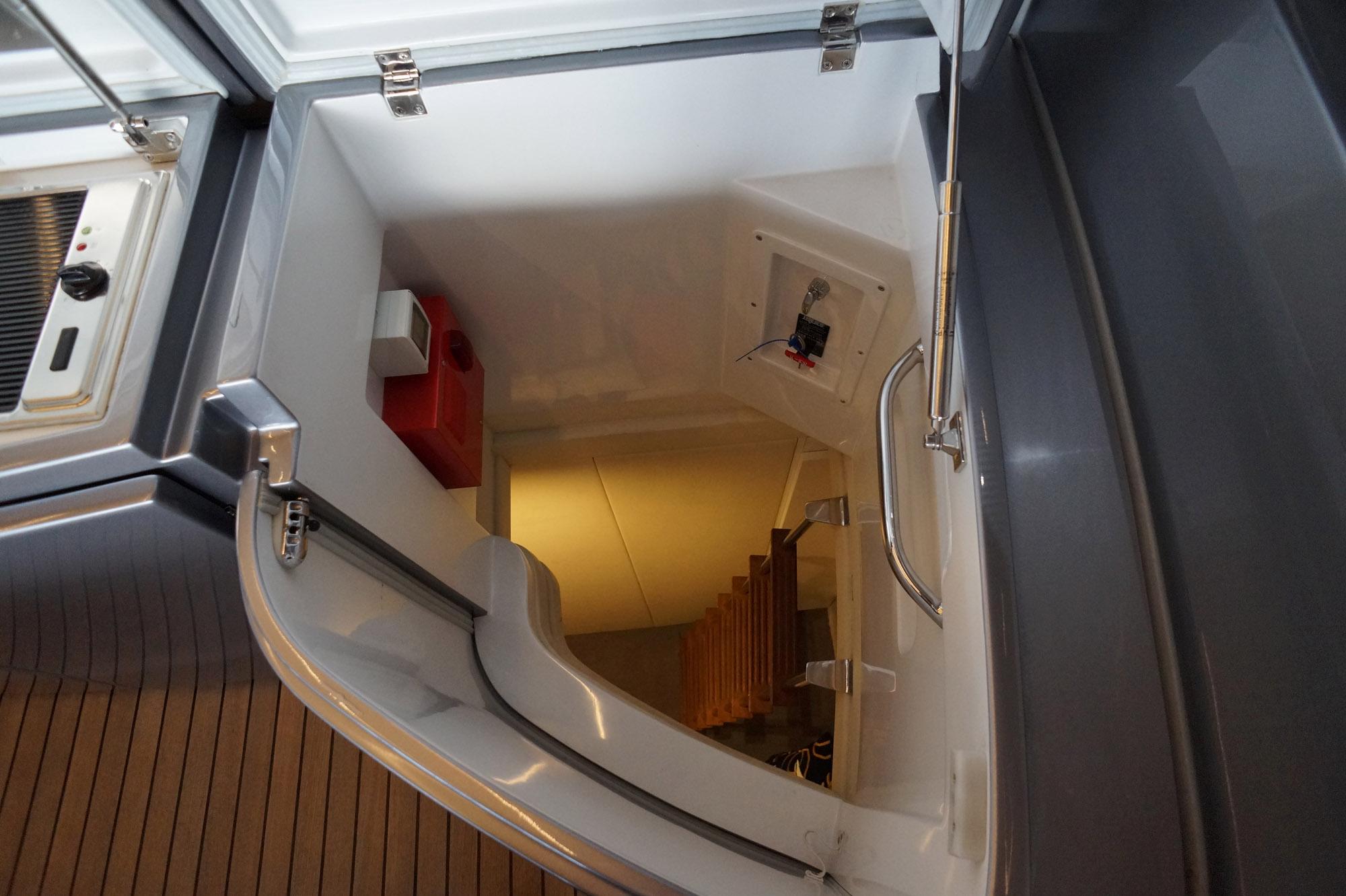 Staircase leading below deck on 2016 Pershing 70 yacht, featuring sleek design and modern finishes.