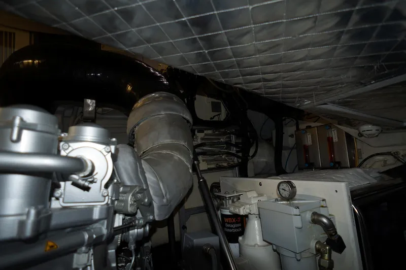 The Office Yacht Photos Pics Engine room of a 2016 Pershing 70 yacht, showcasing mechanical components and piping.