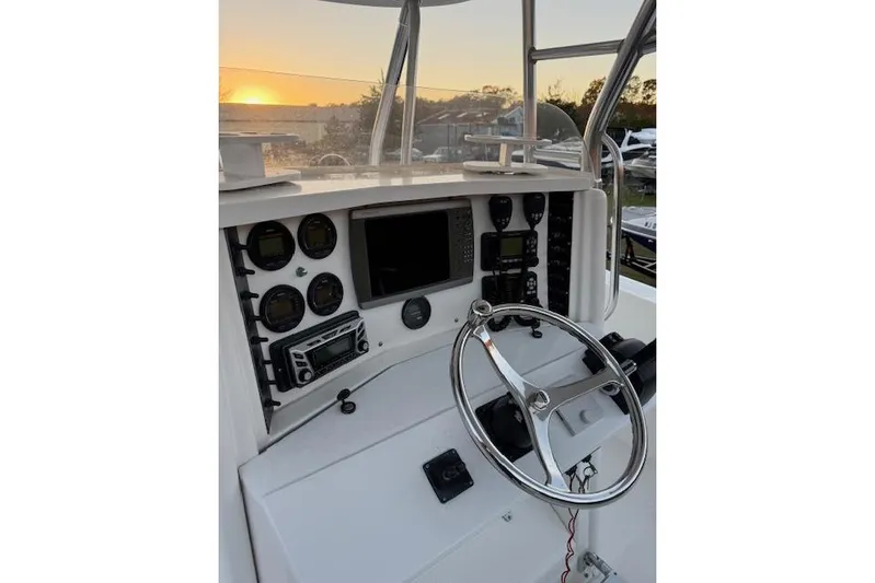  Yacht Photos Pics 2001 Venture 34 Center Console boat dashboard with steering wheel and navigation instruments at sunset.