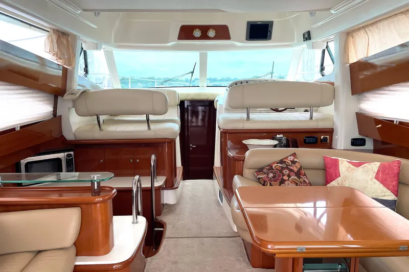 Our Three Buoys Yacht Photos Pics Luxurious interior of 2007 Jeanneau Prestige 46 yacht with elegant seating and wooden finishes.