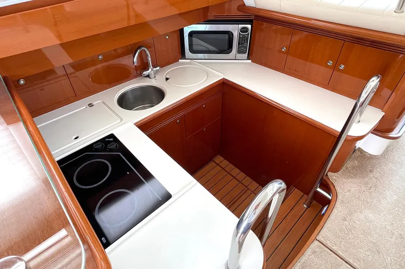 Our Three Buoys Yacht Photos Pics Luxurious 2007 Jeanneau Prestige 46 yacht kitchen with modern appliances and elegant wood finish.