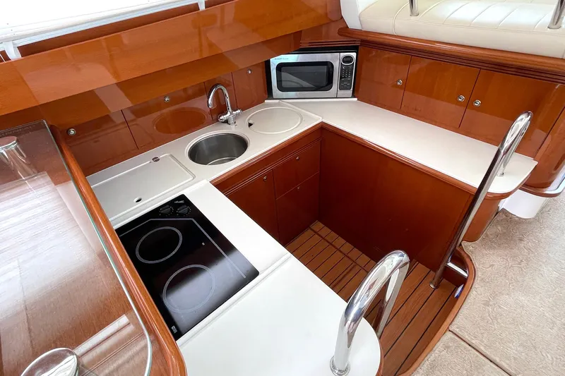 Our Three Buoys Yacht Photos Pics Luxurious kitchen in 2007 Jeanneau Prestige 46 yacht with modern appliances and wood finish.