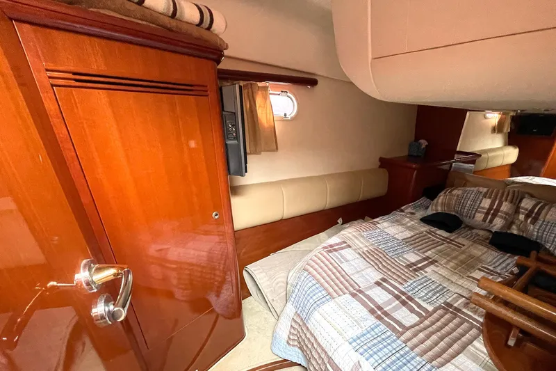 Our Three Buoys Yacht Photos Pics Luxurious cabin interior of 2007 Jeanneau Prestige 46 yacht with wood finish and cozy bedding.