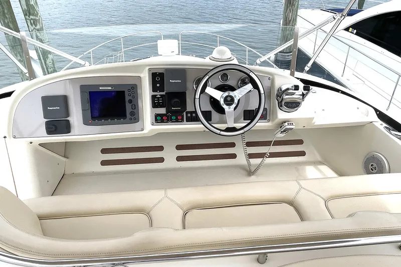 Our Three Buoys Yacht Photos Pics Helm of 2007 Jeanneau Prestige 46 yacht with navigation equipment and steering wheel.