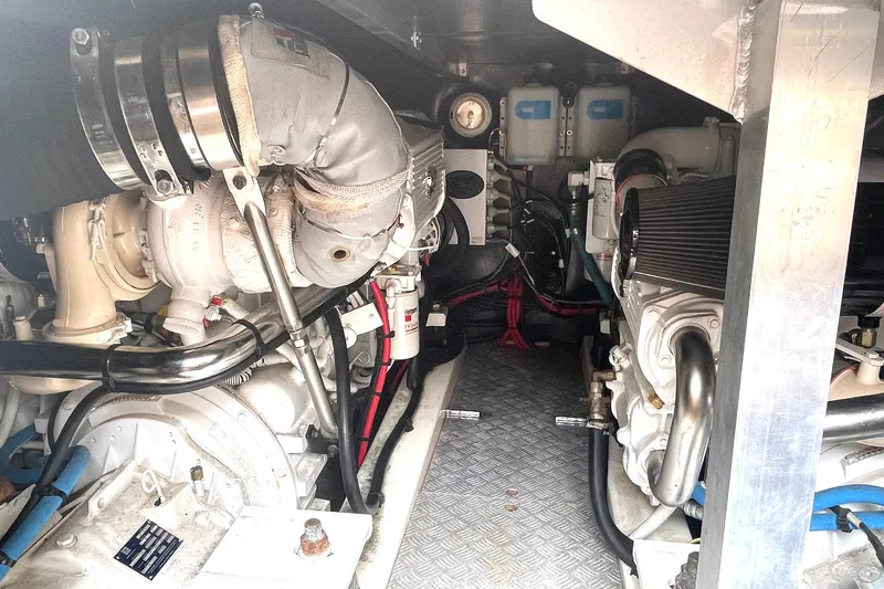 Our Three Buoys Yacht Photos Pics Engine room of a 2007 Jeanneau Prestige 46 yacht, showcasing mechanical components.