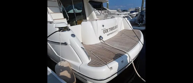 Our Three Buoys Yacht Photos Pics Jeanneau Prestige 46 yacht, 2007 model, docked with teak deck and visible nameplate.