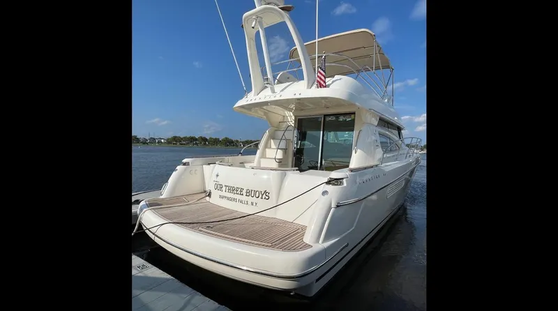 Our Three Buoys Yacht Photos Pics 2007 Jeanneau Prestige 46 yacht docked, rear view, clear sky, water background.