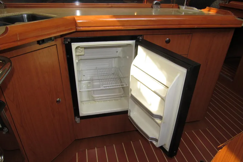 Mariah Yacht Photos Pics 2008 Hunter 41 Deck Salon kitchen with open mini fridge and wooden cabinetry.