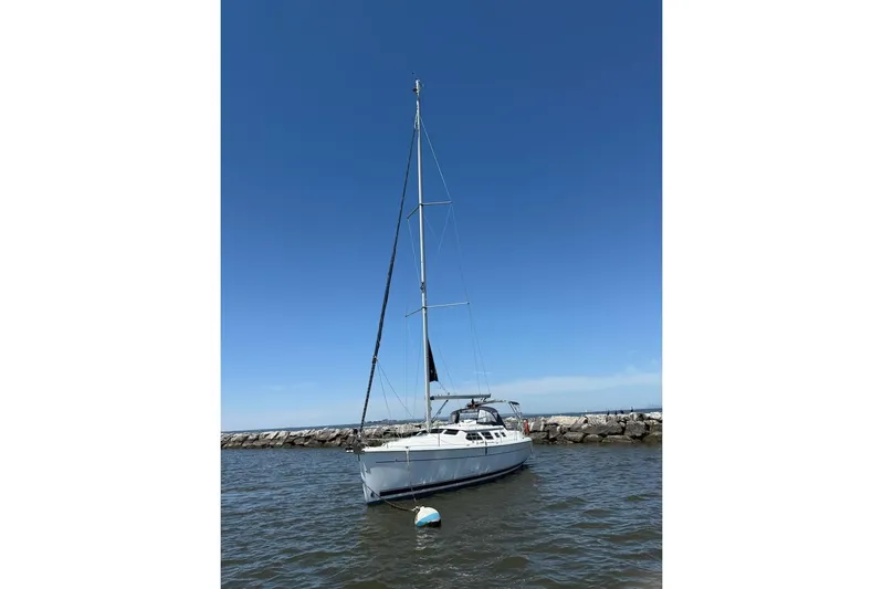Mariah Yacht Photos Pics 2008 Hunter 41 Deck Salon sailboat anchored near rocky shoreline under clear blue sky.