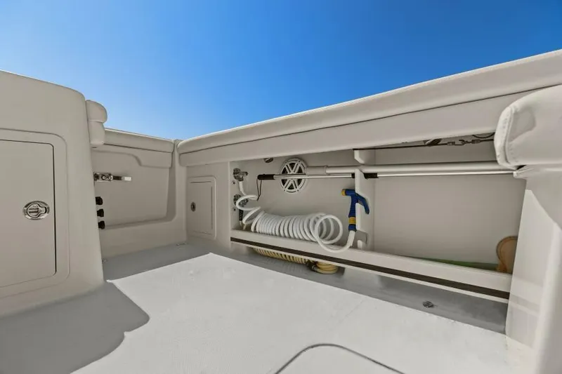  Yacht Photos Pics 2016 Grady-White Freedom 375 boat deck with storage compartment and hose, under clear blue sky.