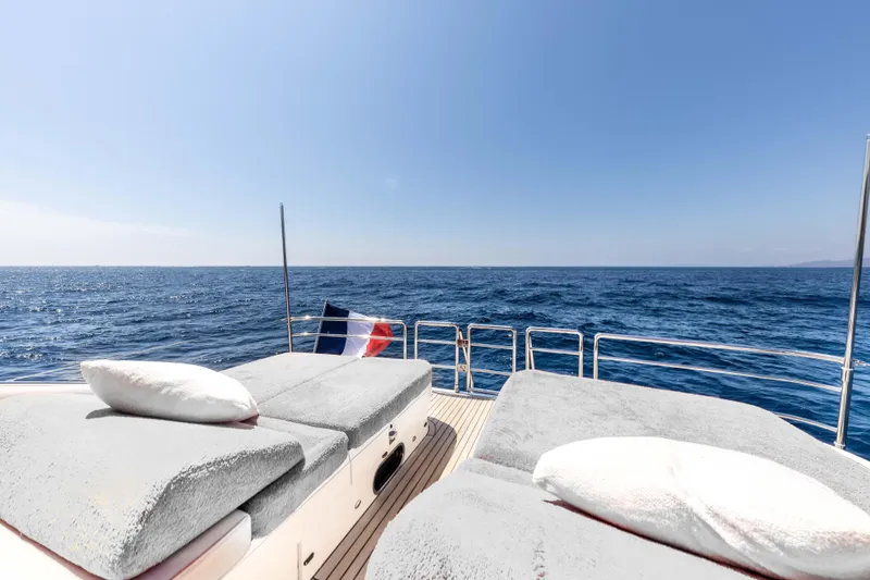 P'tite Bouille Yacht Photos Pics Luxurious 2008 Princess V70 yacht deck with sunbeds, ocean view, and clear blue sky.