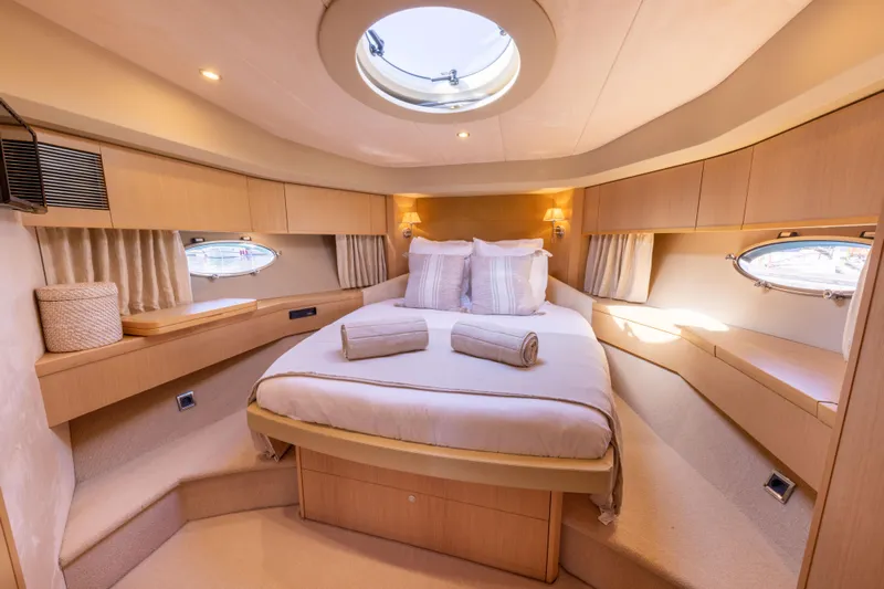 P'tite Bouille Yacht Photos Pics Luxurious cabin interior of 2008 Princess V70 yacht with elegant bedding and ambient lighting.