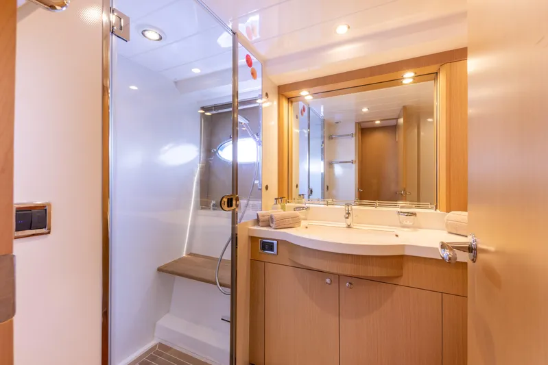 P'tite Bouille Yacht Photos Pics Luxurious bathroom in 2008 Princess V70 yacht with modern fixtures and wooden cabinetry.