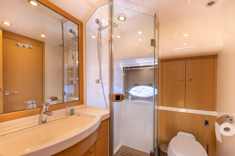 P'tite Bouille Yacht Photos Pics Luxurious bathroom in 2008 Princess V70 yacht with modern fixtures and wooden cabinetry.