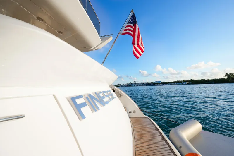 Finesse Yacht Photos Pics 2007 Azimut 68E yacht with American flag, cruising on a sunny day.
