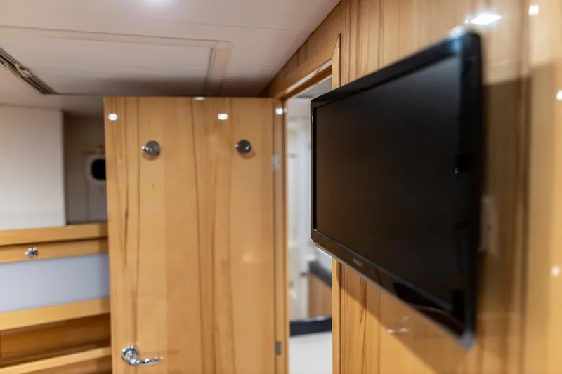  Yacht Photos Pics Interior of 2013 Hanse 630e yacht with wooden paneling and mounted TV.